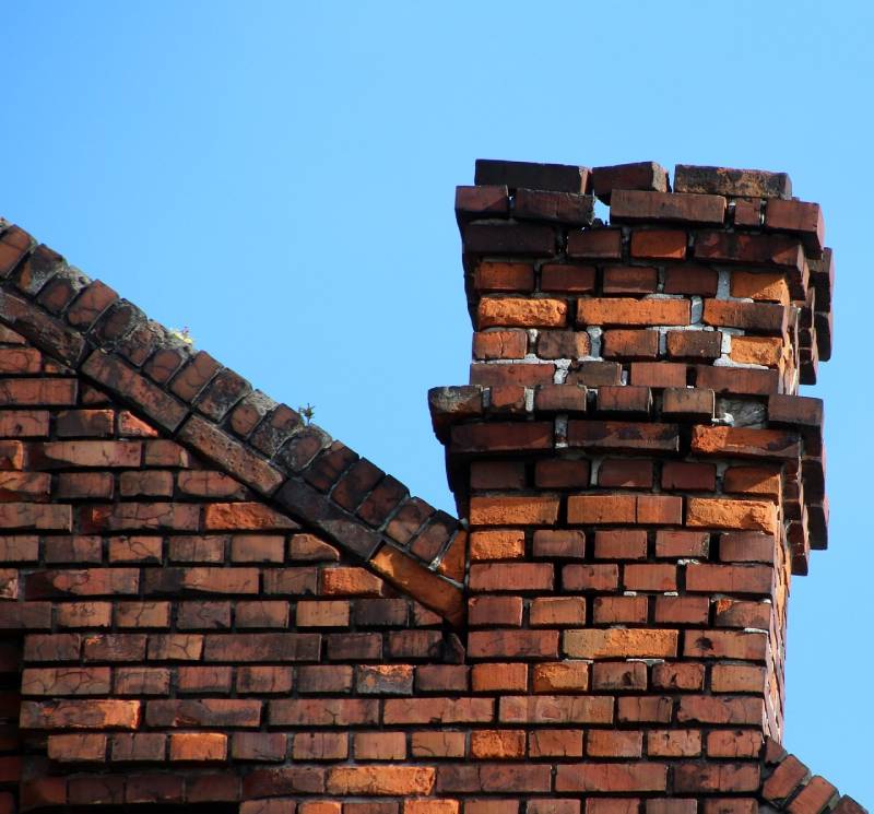 Damaged chimney on an Groveland home showing cracks and missing mortar